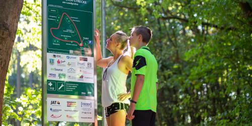 Zwei Menschen stehen vor Schild "Willkommen auf der Trimm-Dich-Strecke am Landgrafen"
