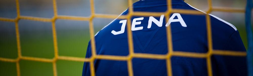 Fußballer durch Tornetz fotografiert, auf T-Shirt steht Jena