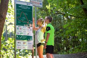 Zwei Menschen stehen vor Schild "Willkommen auf der Trimm-Dich-Strecke am Landgrafen"