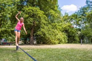 Eine Frau balanciert auf einer Slackline