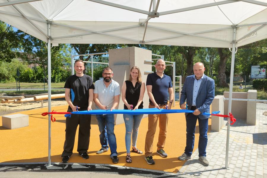 5 Menschen durchschneiden ein blaues Band zur Eröffnung der Parkouranlage