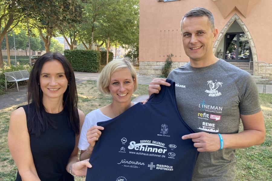 Drei Personen mit Trikot