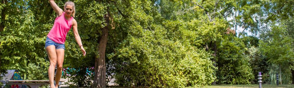 Eine Frau balanciert auf einer Slackline